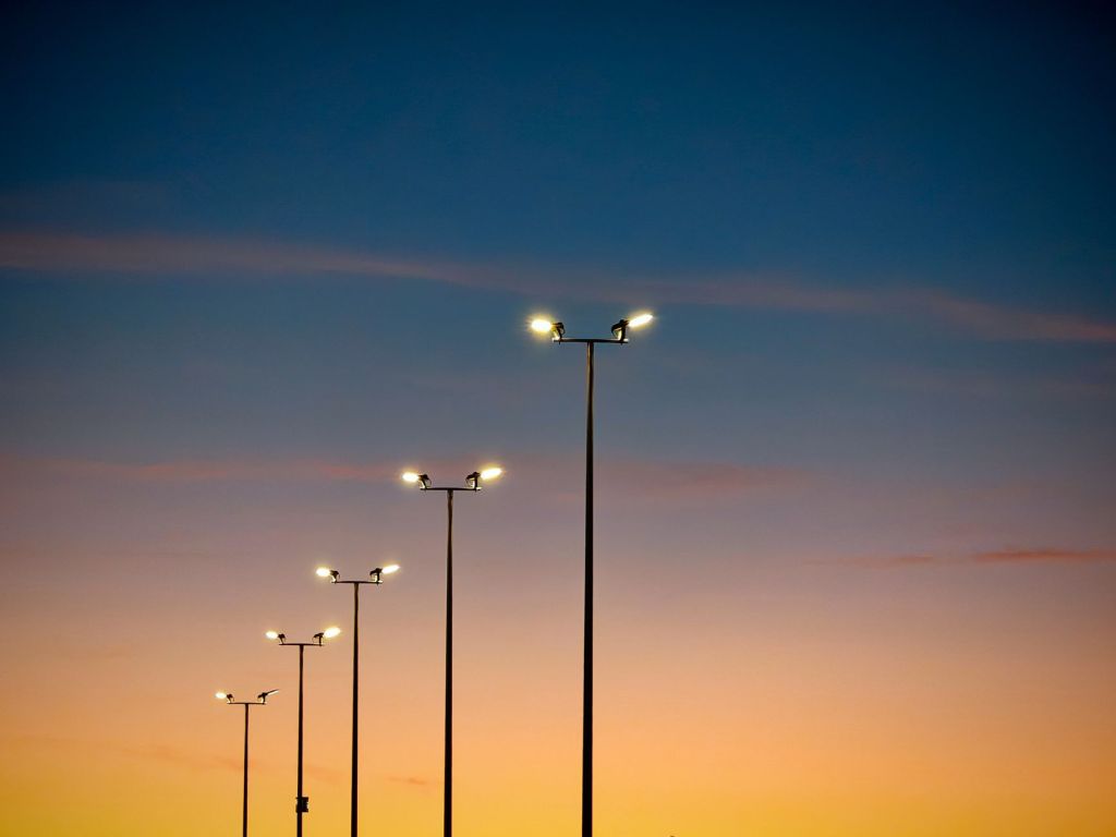 illuminated streetlights against colorful sunset